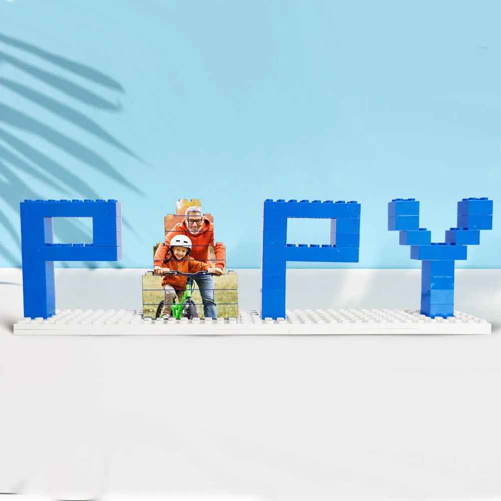 Personalized dad photo puzzle spelled out in blue building blocks showing a father and child on a bike