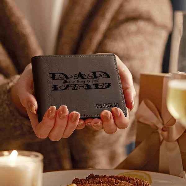MadeMine personalized dad wallet in black leather held in hands with gift box and candle background