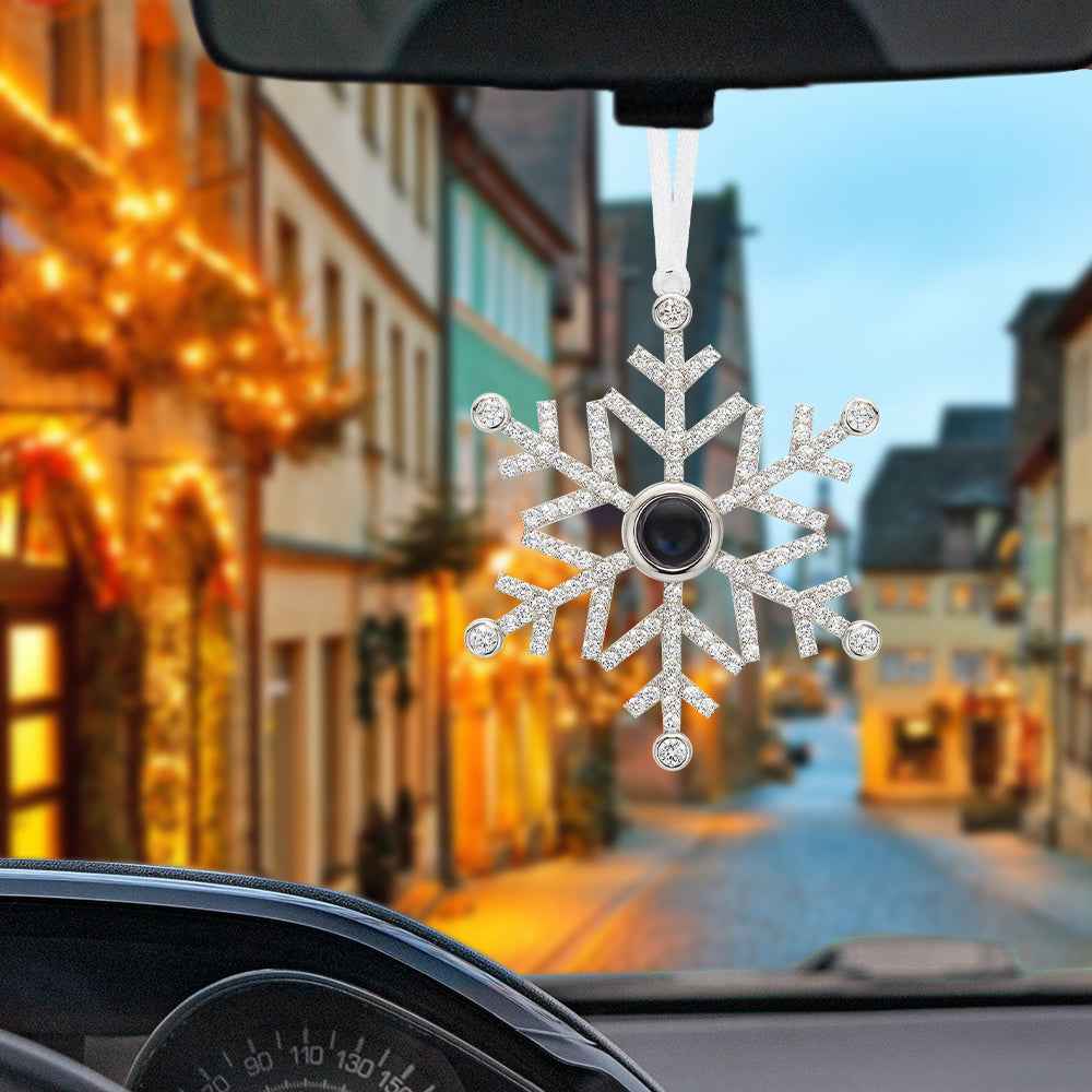 MadeMine personalized photo snowflake ornament hanging inside car with a blurred festive street background