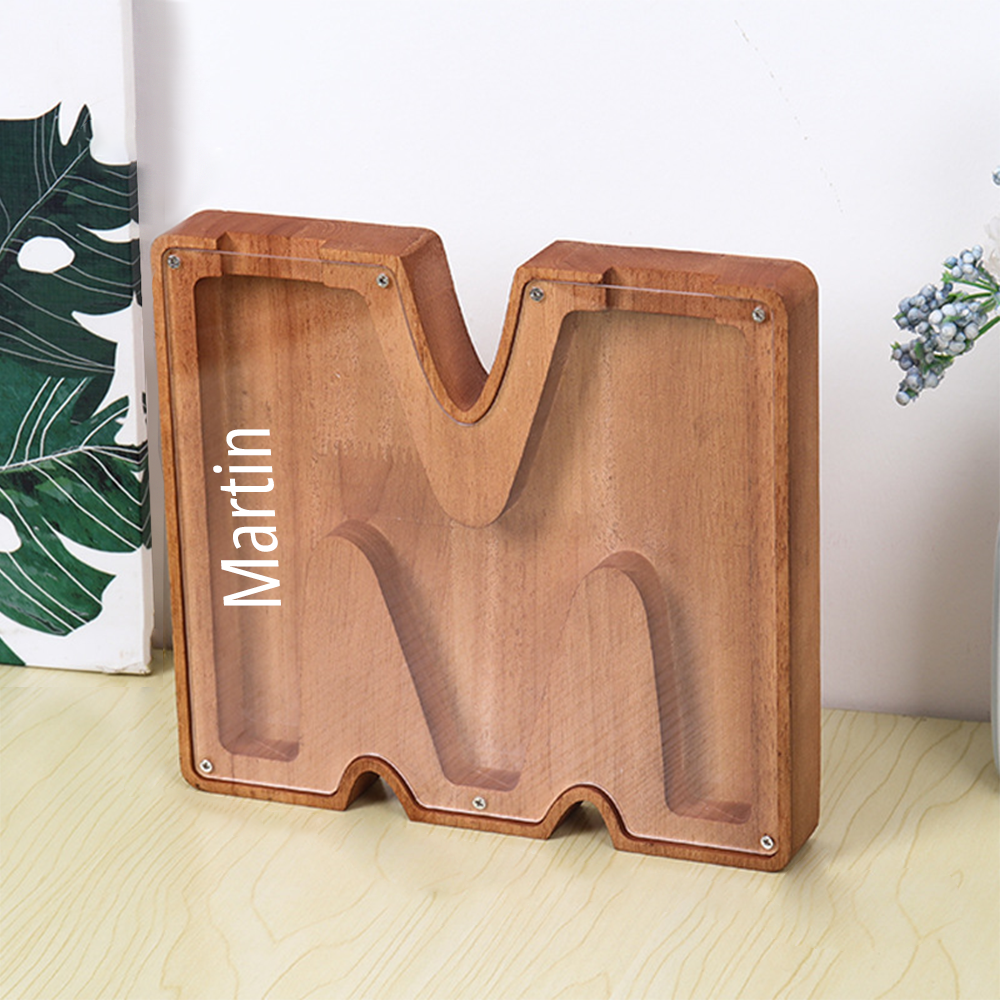 MadeMine personalised wooden piggy bank in letter M shape with acrylic front and natural wood finish