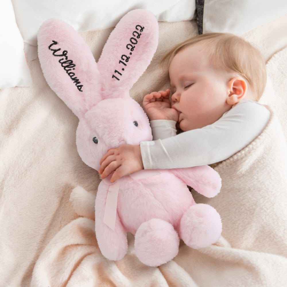Sleeping baby cuddling pink personalised bunny rabbit toy with embroidered name and birthdate on ears