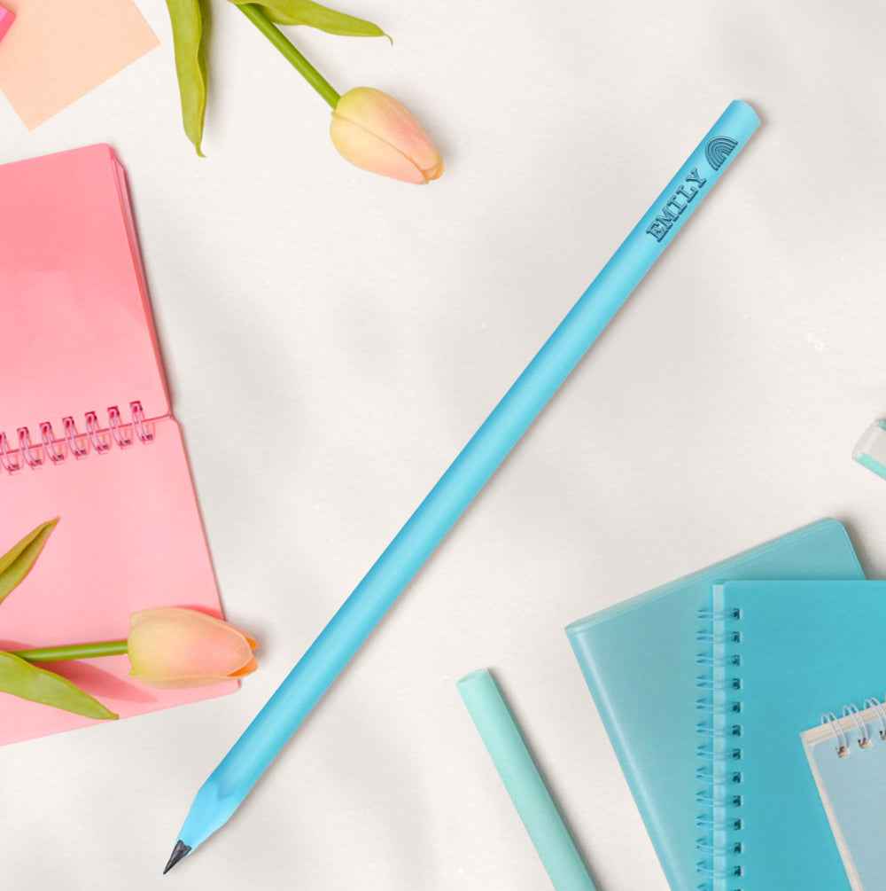 MadeMine pale blue pencil with custom name printed on barrel on desk with notebooks and tulips personalised pencils for school